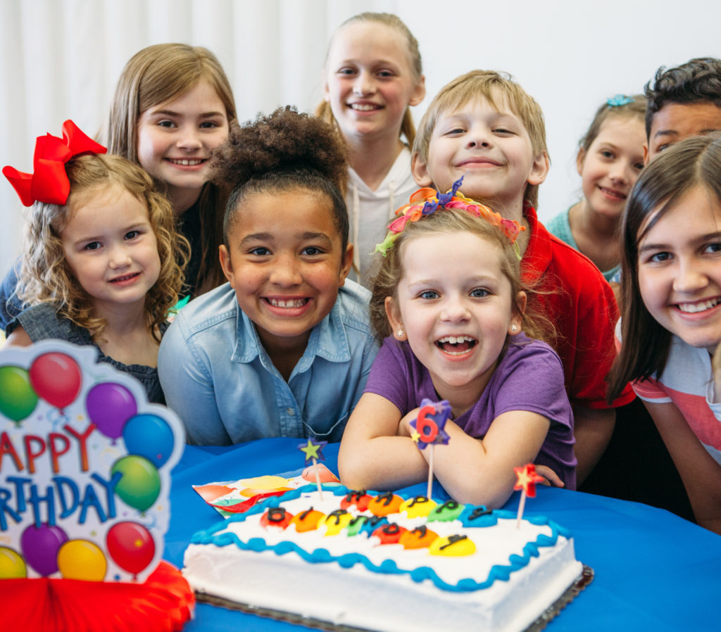 Kid's Celebrating at Birthday Party Over Cake
