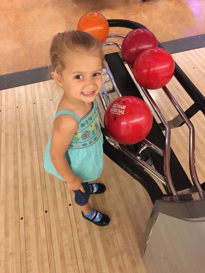 Little girl smiling by ball return